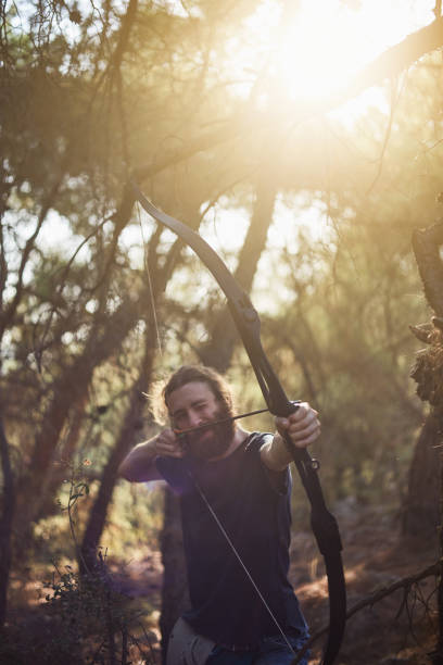istock a young man is preparing to shoot with the bow in the forest 848290718
