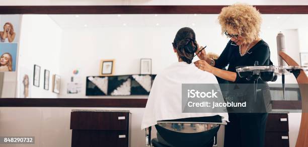 Foto de Estilista De Cabelo Feminino Trabalhando No Cabelo De Uma Mulher No Salão e mais fotos de stock de Cabeleireiro