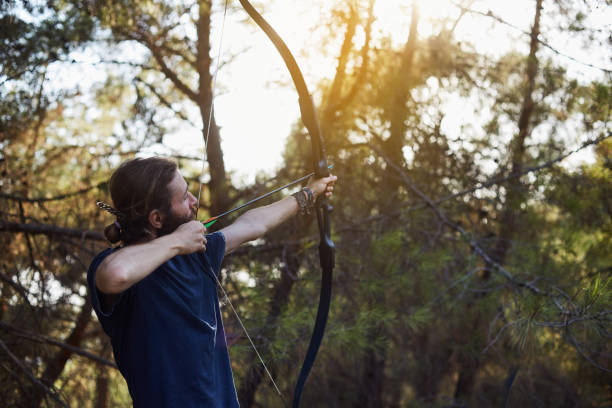istock a young man is preparing to shoot with the bow in the forest 848297338