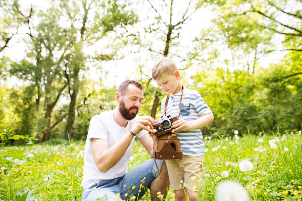 istock Young father with little boy with camera in summer park. 848297542