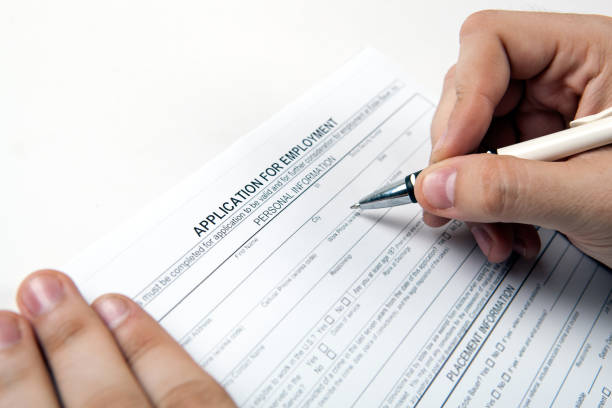 istock human hand and the form of the document application for employment 848298342