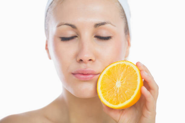 istock Woman with eyes closed holding orange slice 848307820