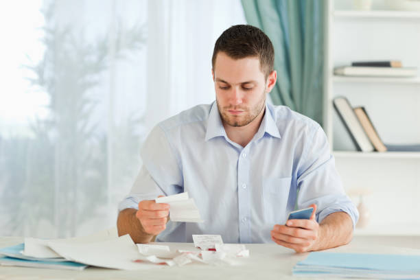 istock Businessman with pocket calculator checking invoices 848310930