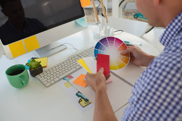 istock Designer holding color swatch while sitting at desk in office 848311454