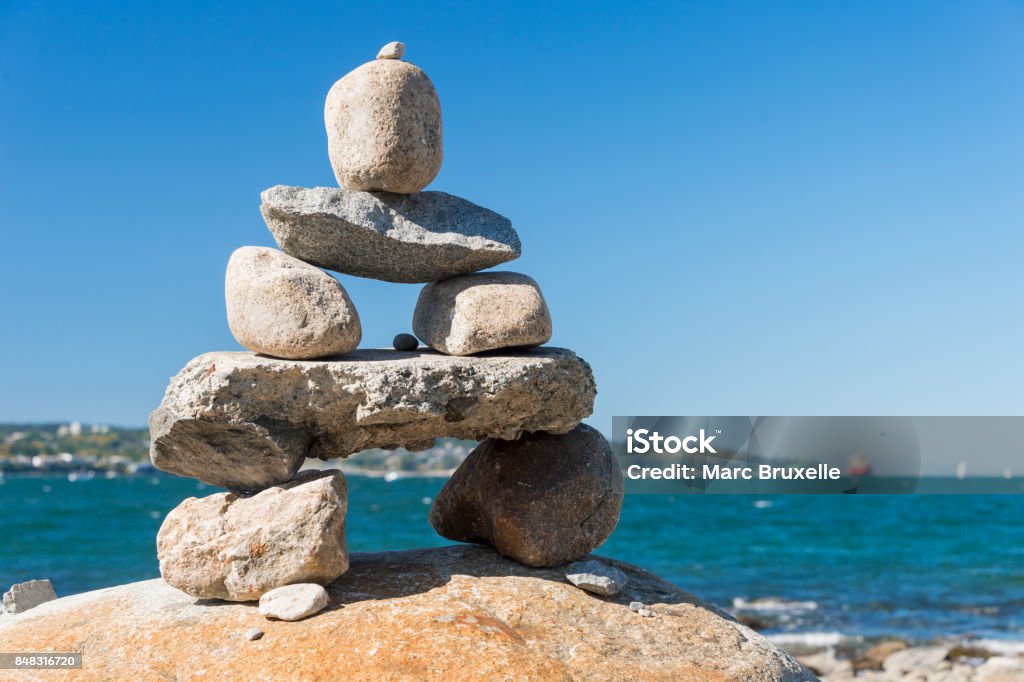 Inukshuk Rock balancing in Vancouver stone stacking garden Inukshuk Rock balancing in Vancouver stone stacking garden (English Bay Beach) Balanced Rock Stock Photo