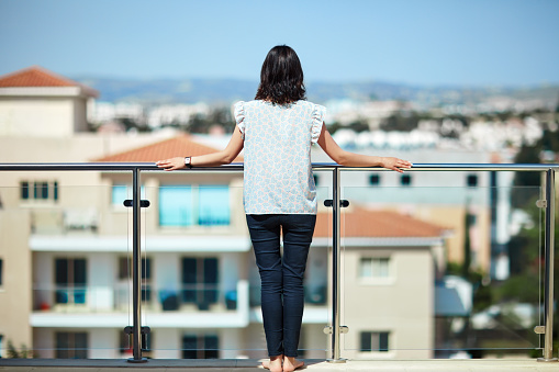 Beautiful woman enjoying cityscape standing on rooftop