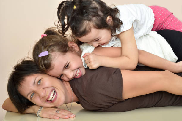 istock Mother and daughters laying and laughing 848322094