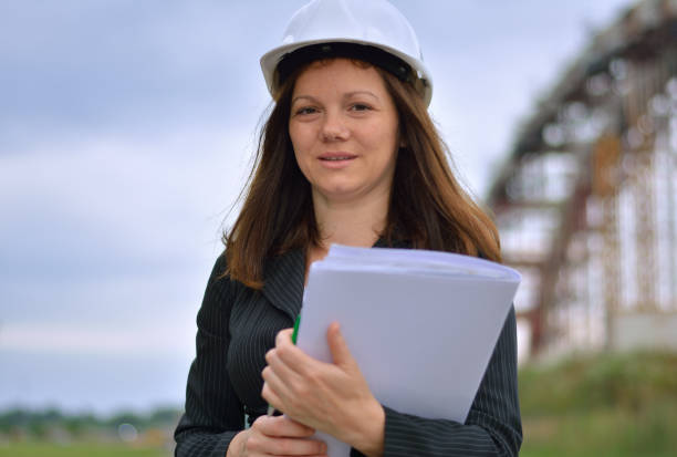 istock Female architect with plans and hardhat 848326004