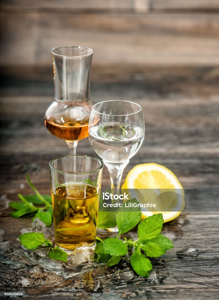 Alcoholic Drinks ice lemon mint leaves Food beverages Alcoholic Drinks with ice, lemon and mint leaves on wooden background. Food beverages Herb Stock Photo