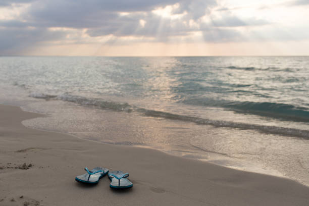 istock beach slippers on the sand at sunset and sea 848336664