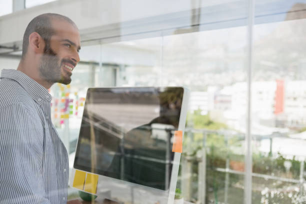istock Smiling designer looking away seen through glass 848351846