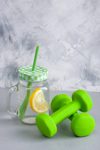 istock Mason jar with lemon green dumbbells on gray concrete background. 848353700