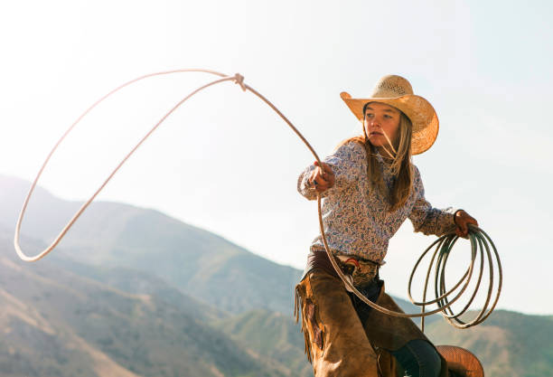 junge cowgirl drehte ein lasso - cowgirl stock-fotos und bilder