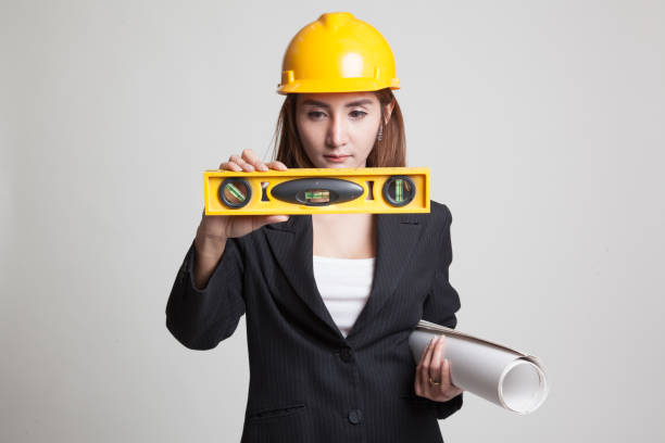istock Asian engineer woman with blueprints and level. 848366098