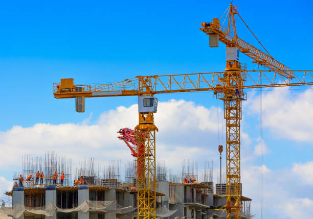 istock Cranes and workers at construction of residental building. 848380620