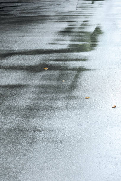 istock wet asphalt sidewalk with rain puddles 848381498