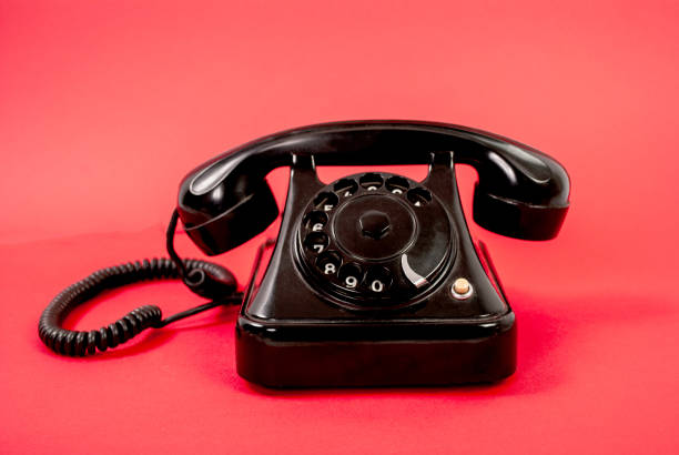istock Retro black phone isolated on a red background 848394486