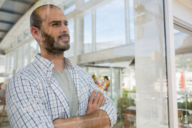 istock Thoughtful designer with arms crossed seen through glass 848397822