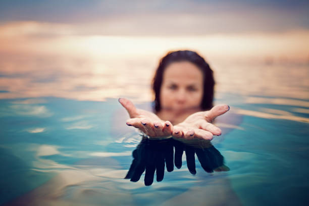 Woman is showing her hands in the ocean