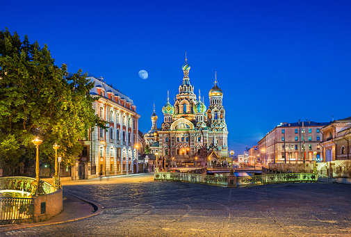 A blue summer night over the Cathedral of the Savior on Blood in St. Petersburg and a bright moon in the sky