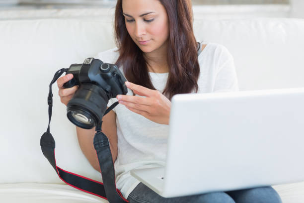 istock Woman holding a laptop and a camera 848441994