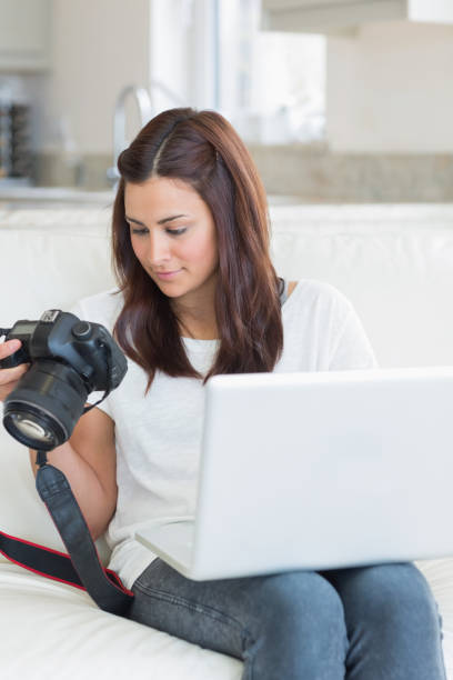 istock Woman viewing photos while holding a laptop 848442018