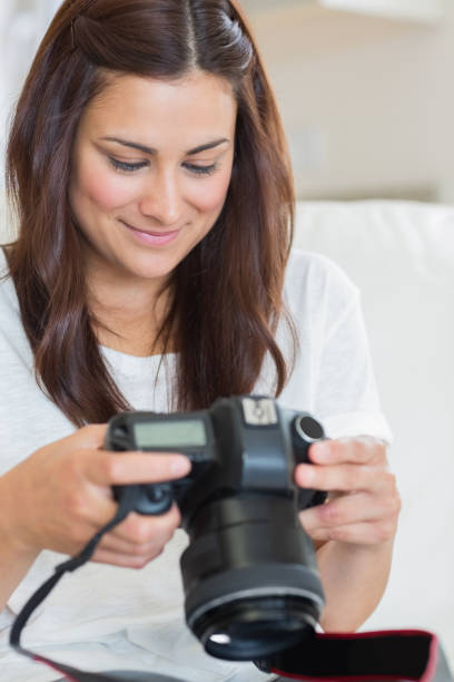 istock Brunette viewing photos while sitting on the sofa 848442160