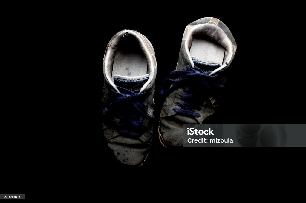 Worn out old sneakers Worn out old sneakers with black background Japan Stock Photo