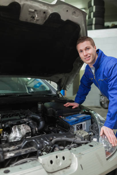 istock Happy mechanic repairing car engine 848459906