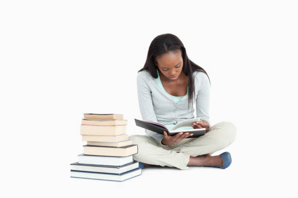 istock Young woman reading next to a stack of books 848461734