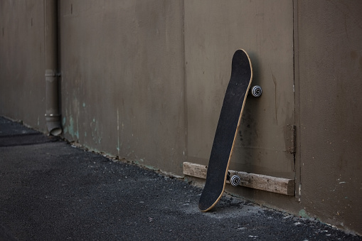 Skateboard leaning by wall