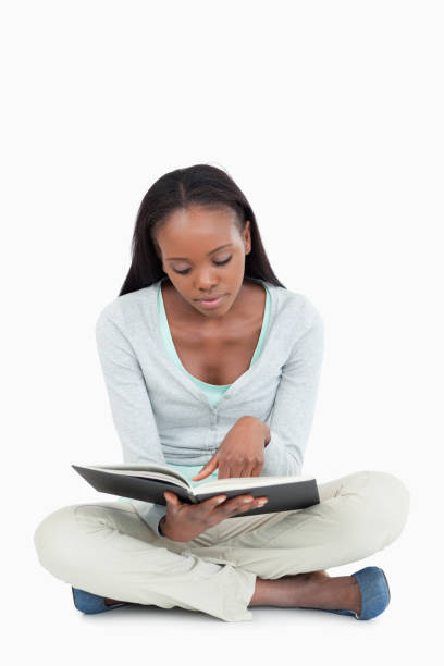 istock Young woman sitting on the floor focused on her book 848481990