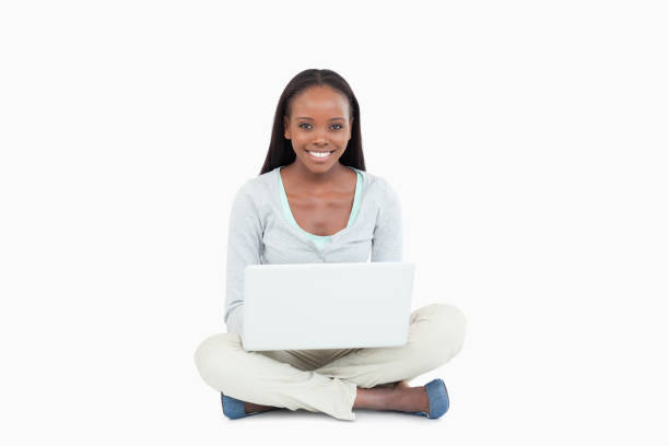 istock Smiling young woman sitting on the floor with her laptop 848482010