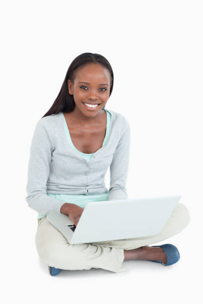 istock Smiling young woman with laptop on the floor 848482030