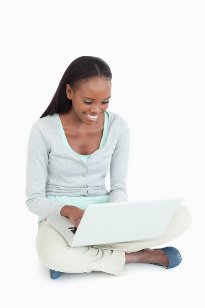 istock Smiling woman working on her laptop sitting on the floor 848482040
