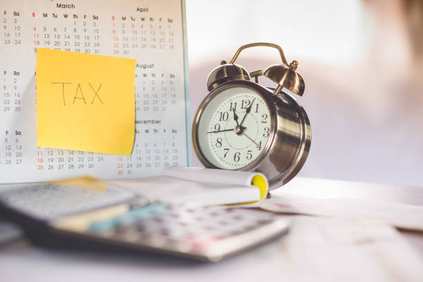 istock tax word note on calendar, alarm clock and calculator on table 848484112