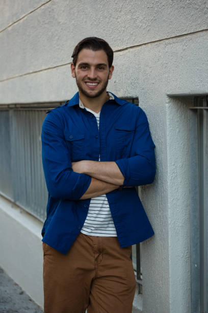 istock Smiling man with arms crossed leaning on wall 848489208