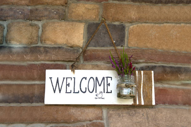 istock Rustic white wood welcome sign hanging on brick wall 848501988