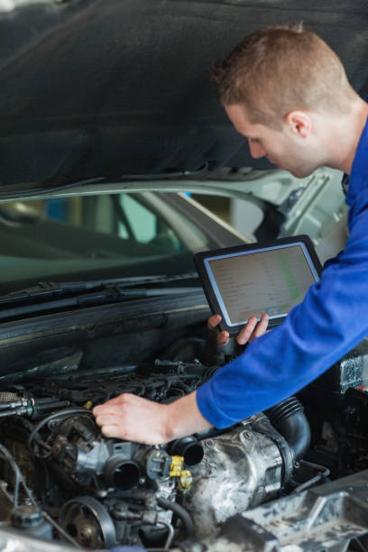 istock Repairman with tablet pc repairing car engine 848505544