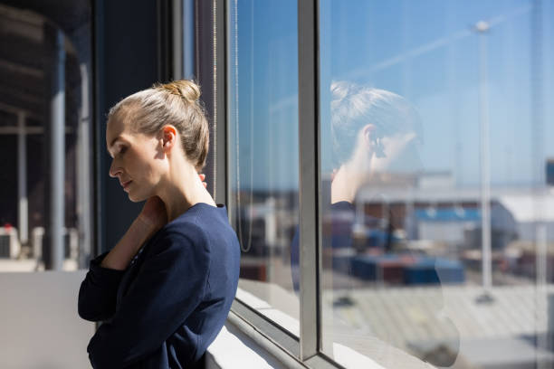 istock Tired businesswoman looking lown while standing by window 848538538