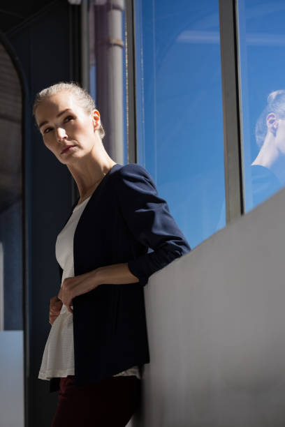 istock Thoughtful businesswoman looking away while standing by windoew in office 848538552