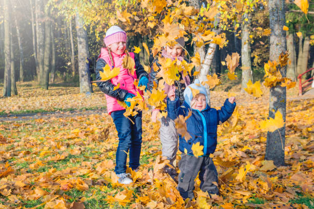 istock Children play in autumn Park.Falling leaves from trees. 848539208
