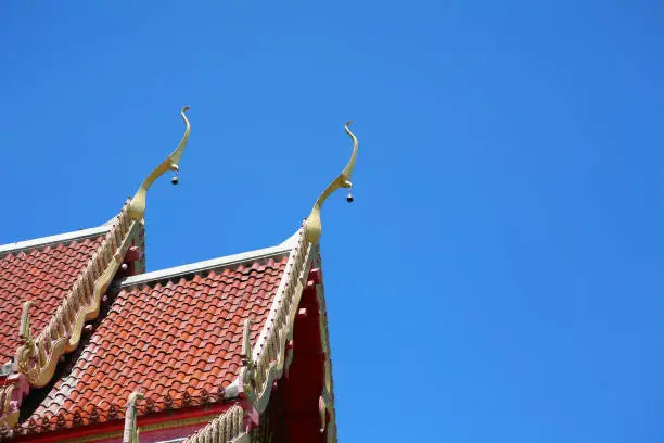 Photo of Thai temple roof in clear blue sky