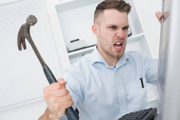istock Frustrated man hitting computer monitor with hammer 848556832
