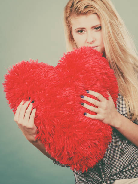 istock Sad woman holding red pillow in heart shape 848567160