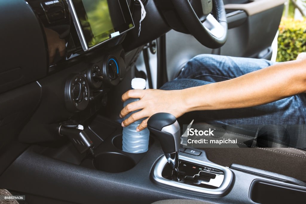 Frau Hand mit Trinkwasser Flasche auf Getränkehalter - Lizenzfrei Ausrüstung und Geräte Stock-Foto