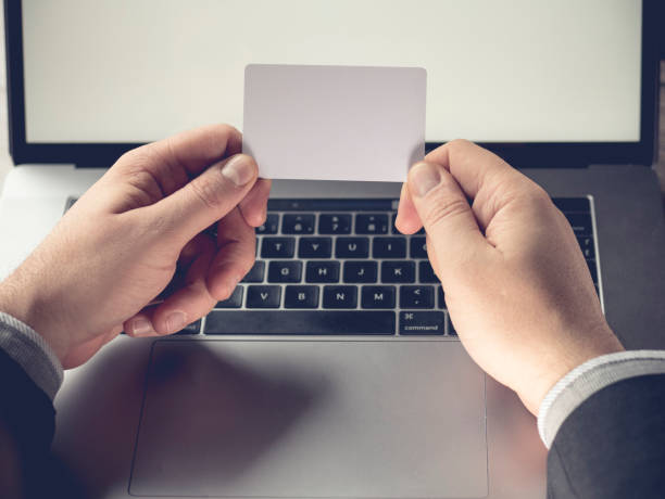 istock Businessman holding a blank white card on a laptop background 848584106