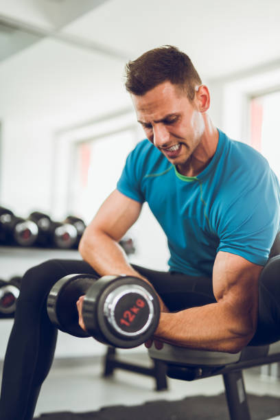 istock Muscular man doing bicep curls with a dumbbell. 848596190