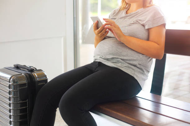 young pregnant woman with suitcase at airport - bus family travel destinations women imagens e fotografias de stock