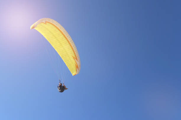 istock Man flying on a paraglider on the blue sky background 848610178